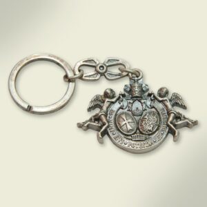 Llavero en metal plateado con escudo de la Hermandad. 5C9,2 cm.